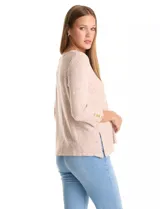 Buzo de tejido soft color beige con textura jaspeada, cuello redondo, mangas tres cuartos con detalle de botones en los puños y tajos laterales en el ruedo.