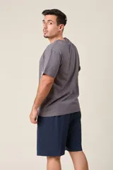 Bermuda de friza color gris melange, de corte suelto, con cintura elástica y cordón de ajuste negro.