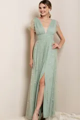 Vestido largo de fiesta color verde agua, con escote en V profundo y mangas cortas con volados. Confeccionado en tul con bordado de estrellas brillantes, presenta una cintura entallada y falda fluida con tajo frontal.
