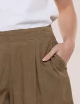 Short color beige de lino y rayón, de tiro medio-alto, con pinzas frontales y cintura trasera elastizada.