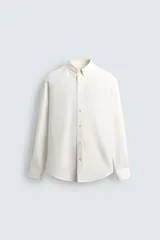 Camisa de corte relajado confeccionada en una mezcla de algodón, lyocell y seda de origen italiano. Presenta cuello abotonado, manga larga con puños abotonados y cierre frontal con botones.