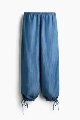 Pantalón de denim liviano, color azul, con cintura elástica y cordones ajustables en los tobillos.