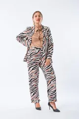 Pantalón largo de poliéster y elastano con estampado abstracto en tonos beige, negro y naranja.