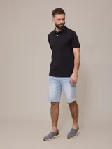 Remera polo negra de piqué de algodón con cuello clásico y tapeta de dos botones. Presenta un pequeño logo bordado en el pecho.