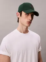 Gorra de béisbol de algodón color verde con visera curva y cierre ajustable en la parte posterior. Presenta el logo de la marca bordado en el frente en tonos contrastantes.