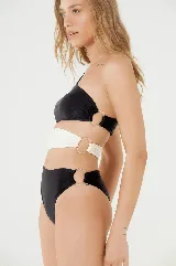 Traje de baño enterizo negro con corte asimétrico, abertura en la cintura y aro decorativo.