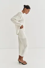 Jersey de punto fino con diseño oversize, cuello redondo y manga larga.