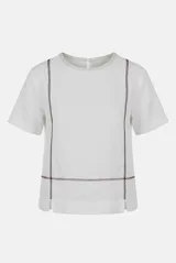 Blusa de lino color beige, de corte recto y mangas cortas, con costuras decorativas pespunteadas en tono rojizo que forman líneas verticales y horizontales.