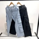 Pantalón de jean cargo de tiro alto, corte recto y bolsillos laterales con doble fuelle.