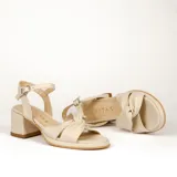 Sandalias de cuero color dorado, con plataforma y taco cuadrado. Presentan tiras cruzadas en el empeine y pulsera al tobillo con hebilla.