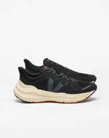 Championes de running Veja modelo Condor 3 ADV, color negro con entresuela en tono crema y detalles en naranja. Presentan un diseño técnico con malla transpirable, logo lateral en tono oscuro y suela con refuerzos en naranja.