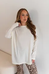 Conjunto de dos piezas compuesto por un buzo de cuello redondo y mangas largas con diseño holgado y un pantalón de corte recto y tiro alto. Ambas prendas están confeccionadas en tejido de punto acanalado.