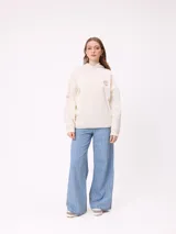 Canguro color crema con capucha y estampado grande en la espalda de un sol con un ojo, montañas, mariposas y texto.