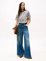 Remera de manga corta con cuello redondo ribeteado en azul marino. Presenta un estampado integral de cachemira (paisley) en tonos azul marino y blanco crema.