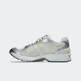 Championes Asics Gel Kayano 14 de estilo retro, color plateado y gris con detalles en dorado, confeccionados con malla y revestimientos sintéticos metalizados, equipados con tecnología GEL en la suela para mayor amortiguación.