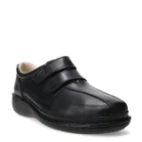 Zapato casual de cuero negro con cierre de doble tira de velcro, diseñado para brindar comodidad y soporte, con suela ergonómica y costuras reforzadas.