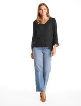 Blusa de rayón color marrón con escote en V, mangas tres cuartos acampanadas y ruedo asimétrico. Presenta detalles de bordado suizo y calados florales en puños y ruedo, con terminación festoneada.