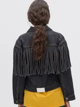 Campera de denim de algodón color negro con efecto lavado, cuello camisero, cierre frontal con botones metálicos y flecos en la parte delantera.