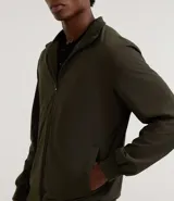 Campera bomber azul con cuello alto, cierre frontal con cremallera, bolsillos laterales y puños y cintura elastizados.