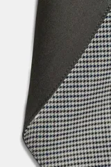 Capucha de diseño estructurado con exterior liso y forro interior con estampado de cuadros. Presenta un cierre frontal con lazada.