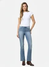 Jean flare de tiro alto, color celeste claro desgastado, con cierre de botón y cremallera.