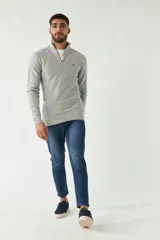 Sweater azul marino de punto con cuello alto y medio cierre con cremallera. Tiene mangas largas y logo bordado en el pecho. Corte regular.