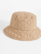 Gorro tipo bucket color beige con diseño capitoneado en forma de rombos.