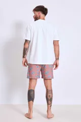 Short de baño de corte clásico en color celeste claro con estampado de pequeñas aves en tono oscuro. Cuenta con cintura elástica y un pequeño parche decorativo en el ruedo.