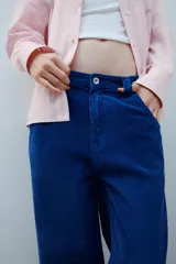 Pantalón de tiro medio confeccionado en pana color azul, de corte baggy con pierna ancha, estilo clásico de cinco bolsillos y cierre frontal con cremallera y botón metálico.