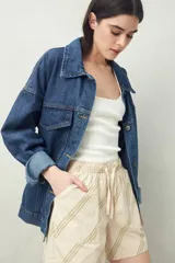 Short color beige con estampado de hojas en verde, cintura elastizada con cordón ajustable y bolsillos delanteros.