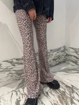 Pantalón calza tiro alto de corte flare con estampado animal print de leopardo.
