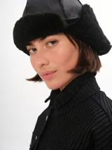 Gorro tipo aviador de cuero marrón con interior de piel sintética color beige.