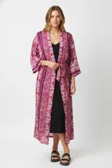 Kimono largo con estampado geométrico en tonos fucsia, violeta y naranja. Tiene mangas 3/4, cuello en V y lazo para ajustar en la cintura.