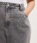 Pantalón de jean modelo wide leg color gris, con cintura tradicional, bolsillos funcionales y detalle de aplicaciones de brillos en la parte superior.