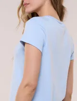 Remera celeste de manga corta, con cuello redondo y detalle calado en el rib del escote, de corte recto y ajuste cómodo.