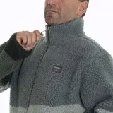 Campera polar de hombre con cierre frontal, cuello alto y bolsillos laterales. Diseño con bloques de color en tonos de verde, gris y negro, con estampado de paisaje montañoso en la parte inferior.