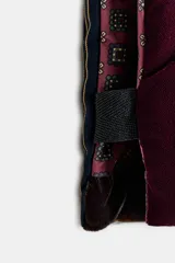 Chaqueta acolchada de diseño patchwork confeccionada en una combinación de tejidos que incluyen terciopelo, lana y satén a rayas. Presenta un corte holgado tipo kimono con forro interior estampado a contraste.