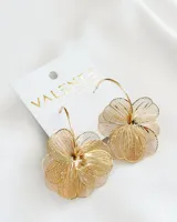 Aros colgantes dorados con forma de flor calada.