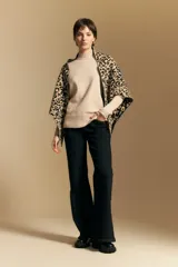 Polera de cuello alto confeccionada en tejido de punto negro, con diseño de textura acanalada en cuello, puños y ruedo, y trama vertical en mangas y espalda.