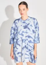 Sweater de punto tipo remerón oversize con diseño batik artesanal en tonos azul y blanco. Presenta silueta amplia, manga caída y etiqueta tejida con monograma en el frente.