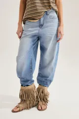 Jean slouchy de tiro alto en color celeste con lavado claro, corte amplio tipo barrel y diseño de perneras curvadas que se estrechan en los tobillos.