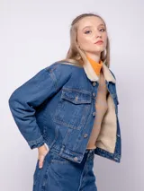 Campera de jean azul con interior de corderito, dos bolsillos grandes en la parte frontal y siete botones metálicos.