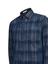 Camisa de manga larga RKF confeccionada en algodón orgánico con textura de cotelé. Presenta un diseño clásico de cuadros escoceses en tonos azules y grises, con cierre frontal de botones, cuello camisero y dos bolsillos en el pecho.