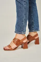 Sandalias de cuero color marrón, con punta cuadrada, tira ancha sobre los dedos, tira al tobillo con hebilla dorada y taco bloque de 7 cm.