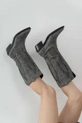 Bota de cuero color marrón con bordado decorativo en el caño, taco bajo y punta fina.