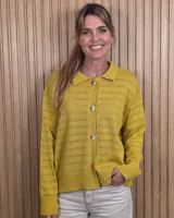 Cardigan de punto color marrón tostado, con cuello camisero, cierre frontal con botones y diseño de rayas sutiles en el tejido. Presenta mangas largas con puños elásticos y corte recto.