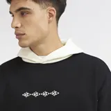 Canguro oversize de felpa con diseño combinado en bloques de color negro y blanco, capucha ajustable, bolsillo tipo canguro y pequeño estampado frontal.