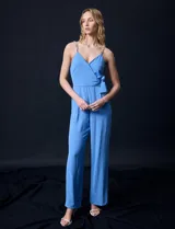 Enterito azul celeste de crepe, con escote cruzado en V, cintura elastizada y pierna ancha. Los tirantes son de cadena metálica.