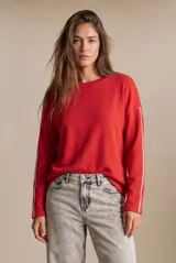 Sweater oversize rojo de algodón peinado, con mangas largas y una línea blanca decorativa a lo largo de cada manga.