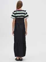 Vestido midi de denim color marrón, con corte holgado, breteles finos con lazos ajustables y detalle de volado en el ruedo.